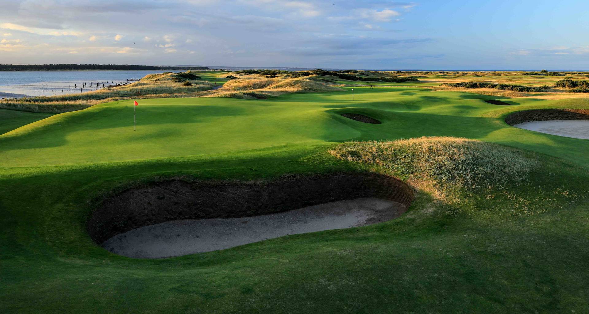 The green on the par 3, 11th hole on the Old Course, St Andrews, with the green on the par 4, seventh hole behind it.
